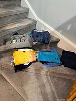 Overall lot showing folded garments on stairs