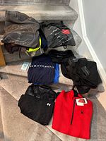 Folded assortment of shirts, pants and jeans on stairs