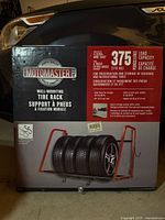 Front of sealed box showing Motomaster wall-mount tire rack image and 375 lb capacity
