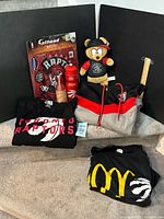 Group shot of all clothing, plush, water bottle, decal, cozy