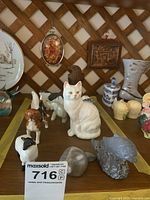 Grouping of porcelain cat, dog, sheep with soapstone seal and fish carvings