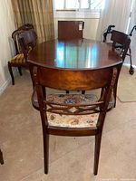 Oval wood dining table with chairs around it