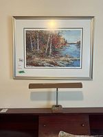 Overall view of framed print with lamp below