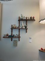 Wood four-tier wall shelf with ceramic and glass miniatures