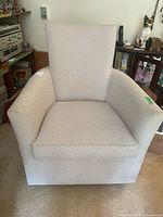 Front view of upholstered swivel rocking arm chair showing overall design and condition