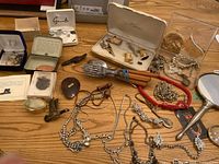 Overview of lot showing jewellery pieces, cufflinks, forks, vanity mirror, magnifier and pill box