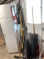 Group of long-handled tools, screens, broom