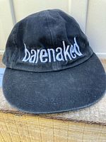 Front of black cap showing white "barenaked" embroidery