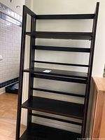 Full view of black folding shelving unit with five shelves