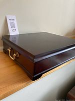 Closed tea chest showing exterior finish and brass-tone handle