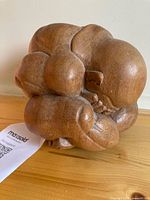 Front view of wooden crying Buddha sculpture