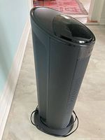 Full view of black tower heater standing upright