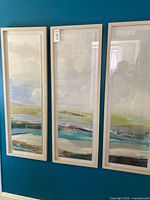 Full view of all three framed artworks mounted on wall