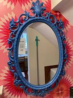 Front view of blue ornate oval mirror