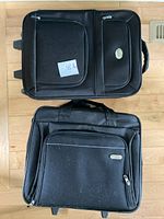 View of both black wheeled suitcases front sides