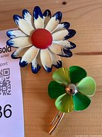 Front view of both brooches showing colours and design