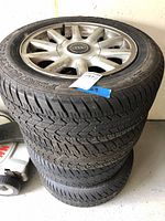 Stack of four Dunlop snow tires mounted on Audi alloy rims