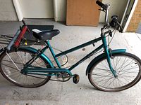 Full left side view of teal Huffy Savannah bicycle with rear rack and accessories