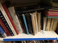 Shelf of large art books and stack of children’s books