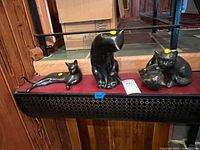 All three cat sculptures on shelf