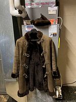 Full view of suede shearling coat and fur hat