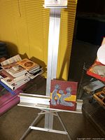 Full view of aluminum easel holding painting