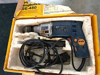 Hammer drill in molded foam tray showing drill body, cord and handle