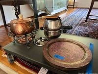 Overall view of both fondue pots and stack of chargers