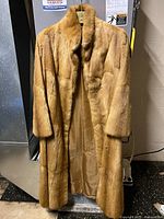 Front view of full-length fox fur coat hanging