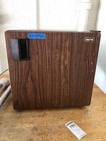 Front view of Sanyo mini fridge showing faux woodgrain exterior and brand badge