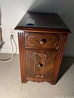 Nightstand front view showing two drawers and carved details
