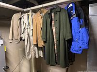 Five outerwear items hanging on rack in basement