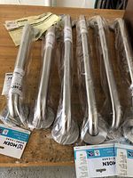 Six sealed Moen grab bars on workbench, plastic wrapped
