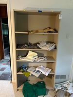 Front view of beige pressed board shelving unit with five shelves