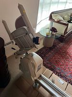 Stair lift chair mounted on rail in room
