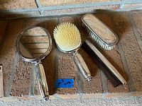 Overview of mirror, two brushes, comb on brick surface