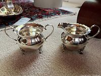 creamer and sugar bowl front view showing shape and feet