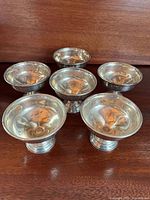All six sterling pedestal bowls on wood surface
