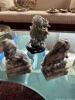 All three stone carvings: two guardian lions and plant sculpture on wood stand