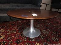 Full view of round wood top tulip pedestal coffee table