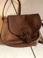 Front view of Coach 9535 bag with flap closed and turn-lock visible