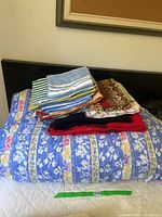 Blue floral patterned queen size duvet cover with folded sheets and blankets on top
