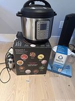 Full lot showing Instant Pot on its box, Brita water jug boxed, and Black & Decker iron