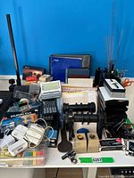 Wide view showing organization of office supplies including notebooks, batteries, staplers, hole puncher, rolodexes and various writing instruments in stands