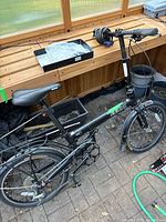 Overall view of black Solo Rock Spin 5 folding bicycle with coiled cable lock on handlebar