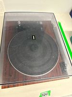 Top view of Yamaha record player with closed clear dust cover showing platter and wood grain base.