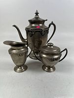 Coffee pot, sugar bowl and creamer front view