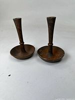 pair of forged iron candlestick holders standing upright