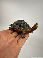 Porcelain turtle figurine in palm for size reference