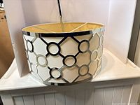 overall view of drum pendant with chrome lattice exterior